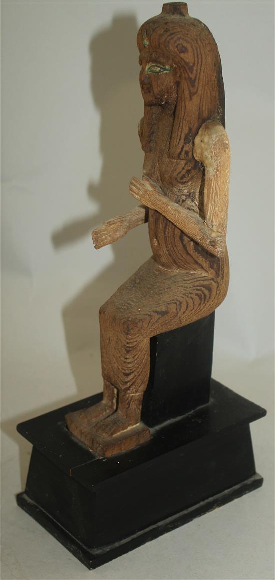 A carved wood figure of a seated ancient Egyptian woman, 12in.